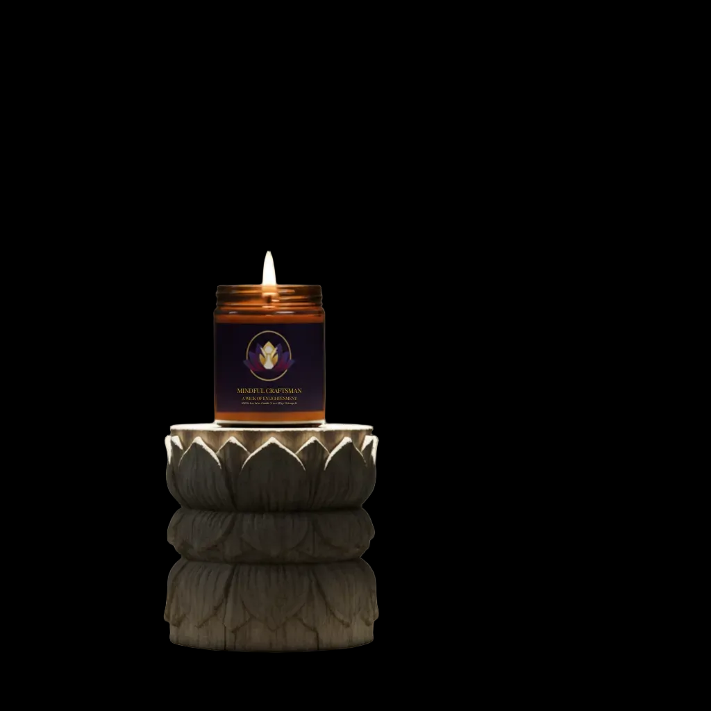Mindful Craftsman signature amber jar candle glowing on a decorative stone pedestal with a black background.
